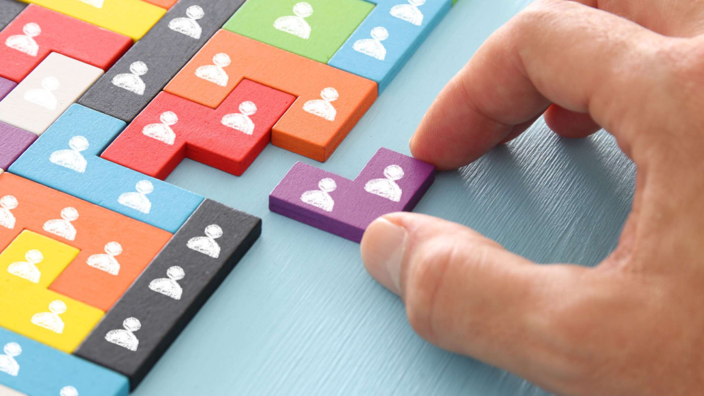 image of tangram puzzle blocks with people icons over wooden table ,human resources and management concept